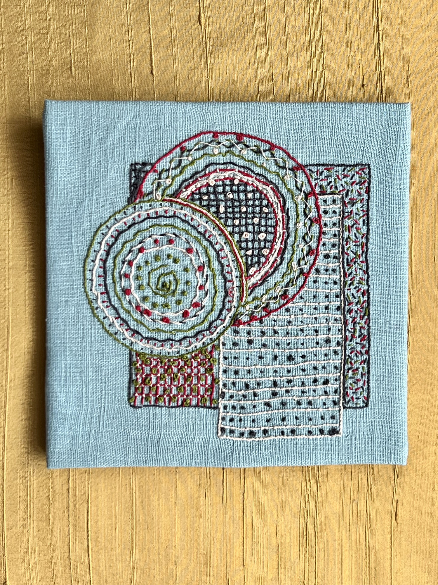 Stitched geometric shapes using various embroidery stitches